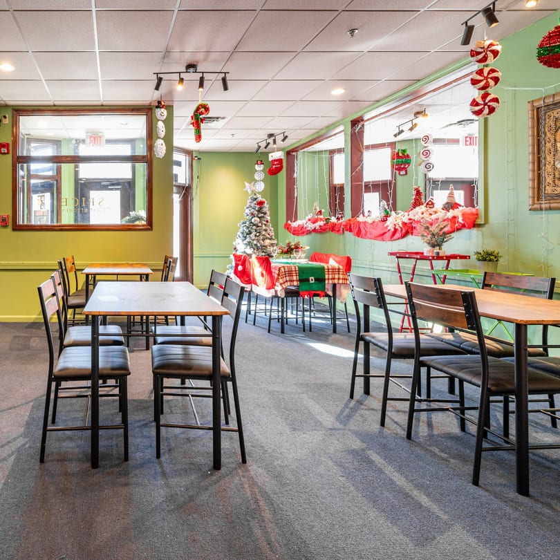 Spice Thai Kitchen dining room decorated for Christmas with tables, chairs, and a Christmas tree.