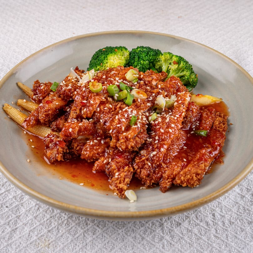 Crispy Thai chicken with sweet chili sauce, sesame seeds, green onions, baby corn, and broccoli.