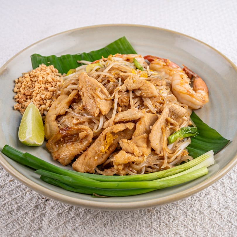 Spice Thai Kitchen's Pad See Ew with chicken and shrimp, garnished with lime and peanuts.